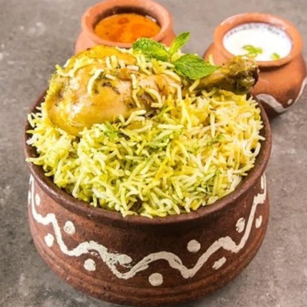 "Chicken Biryani served in traditional clay pot with raita and mint chutney, authentic Indian cuisine"