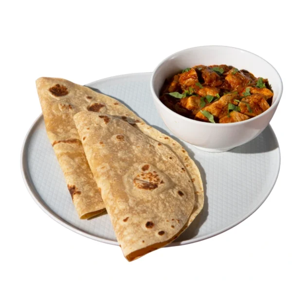 "Homemade butter chicken curry served with fresh chapati flatbread on white plate"