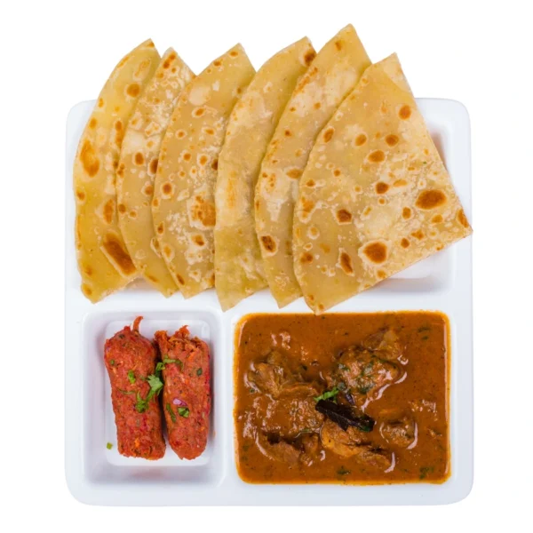 "Indian thali with butter roti, seekh kebab, and mutton curry served on white plate"